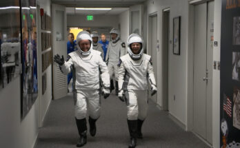 Astronauts walking down hall.