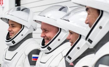 astronauts in white spacesuits pose for portraits