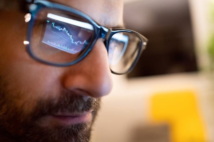 Los gráficos en la pantalla de la computadora se reflejan en las gafas de uno.