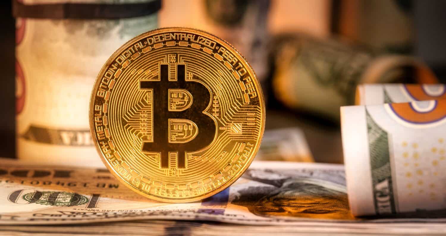 Primer plano de monedas de criptomoneda bitcoin metálicas brillantes en billetes de dólares estadounidenses. El concepto de dinero electrónico descentralizado. Bitcoin es un pago conveniente en el mercado económico global.