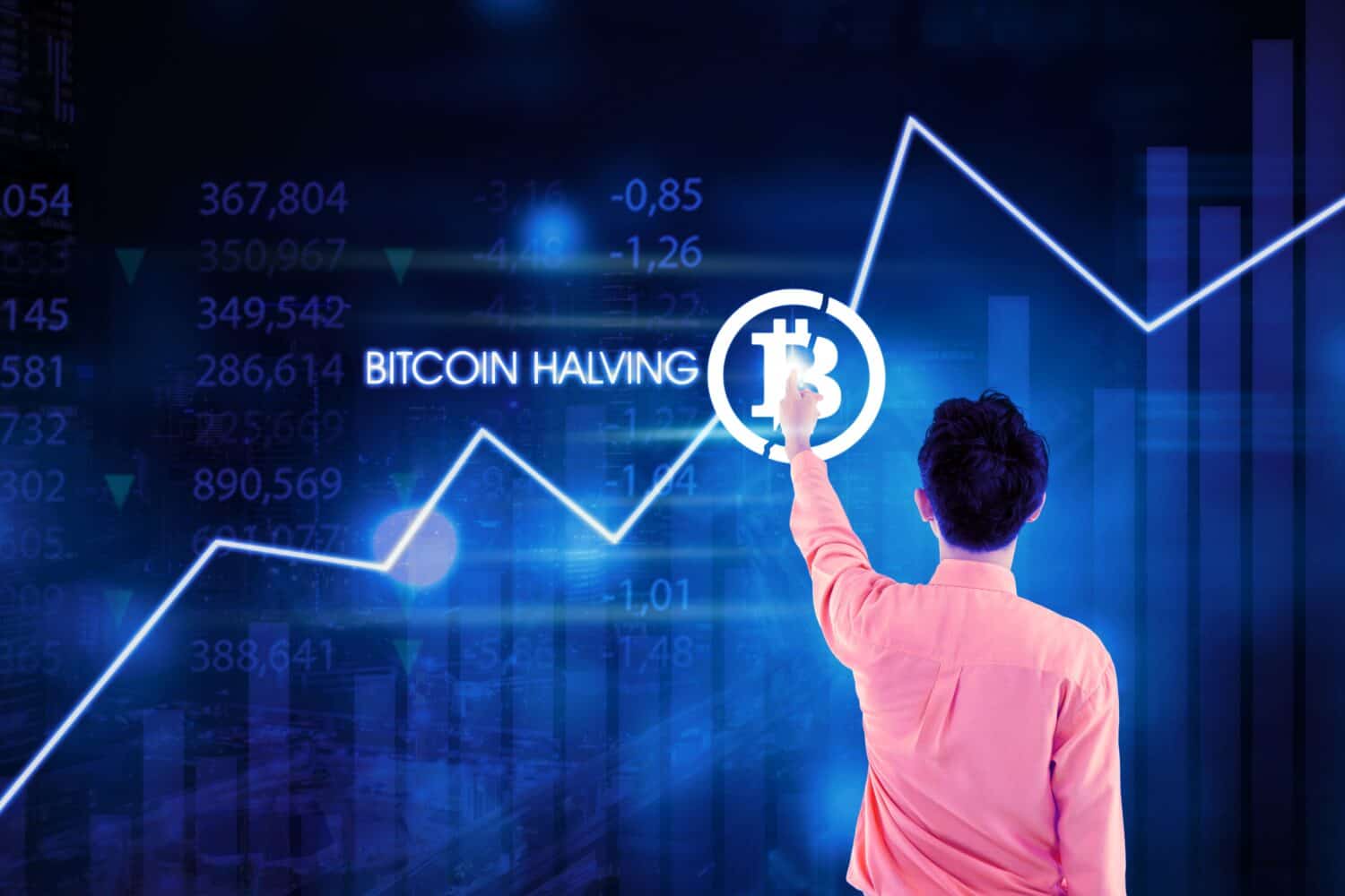Un hombre presiona el ícono de bitcoin. El precio de Bitcoin aumenta en el mercado de criptomonedas después de la reducción a la mitad de Bitcoin