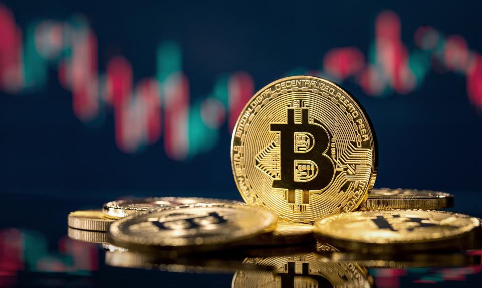 Bitcoin de oro frente a un gráfico de acciones borroso