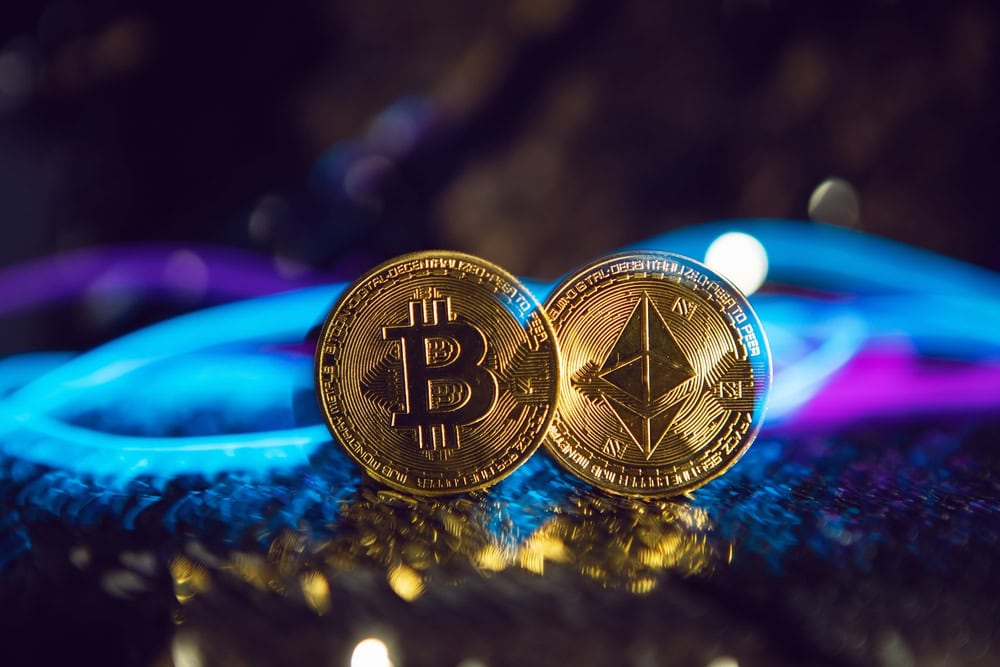 dos monedas de hierro dorado ethereum y bitcoin sobre fondo plateado brillante. Cyberpunk de alambre azul y rosa en el futuro.
