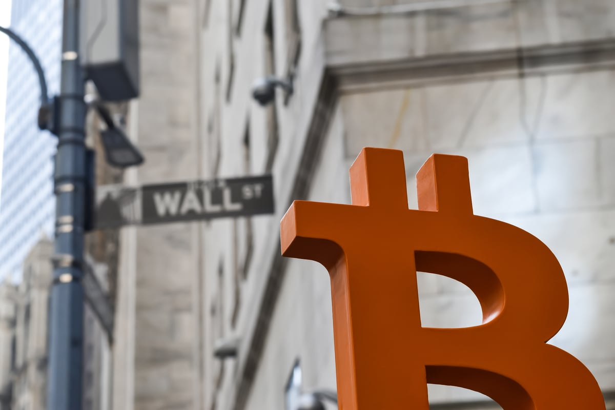 Logotipo de Bitcoin frente a un cartel en Wall Street.