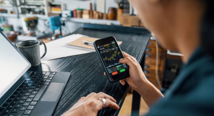 A person looking at a price chart on their smartphone.