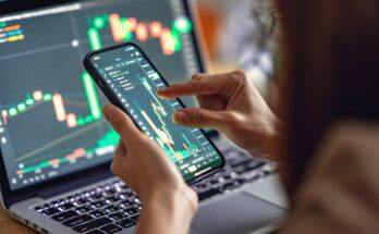 A person analyzing a price chart on a laptop and a smartphone.