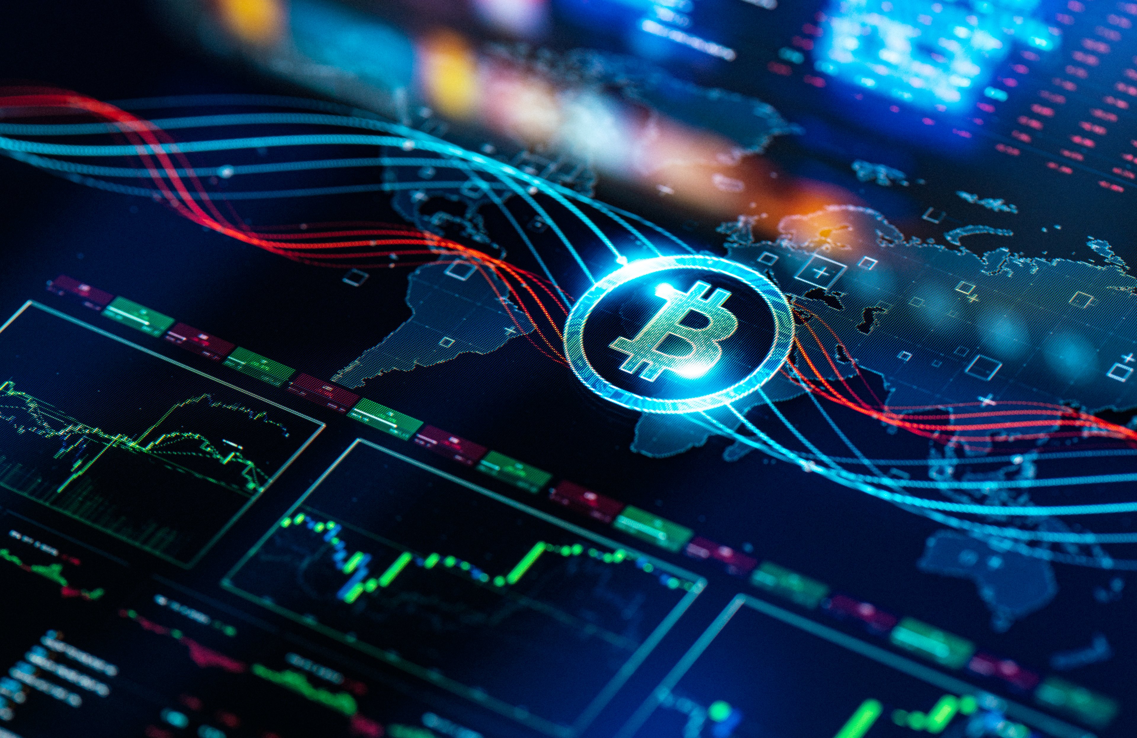 El logotipo de Bitcoin descansa sobre la pantalla de una tableta que muestra un mapa mundial y datos sobre el precio de las acciones.