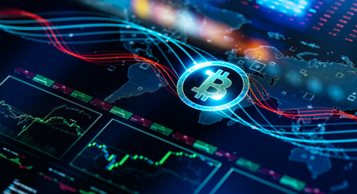 A Bitcoin logo rests on a tablet screen displaying a map of the world and stock price data.