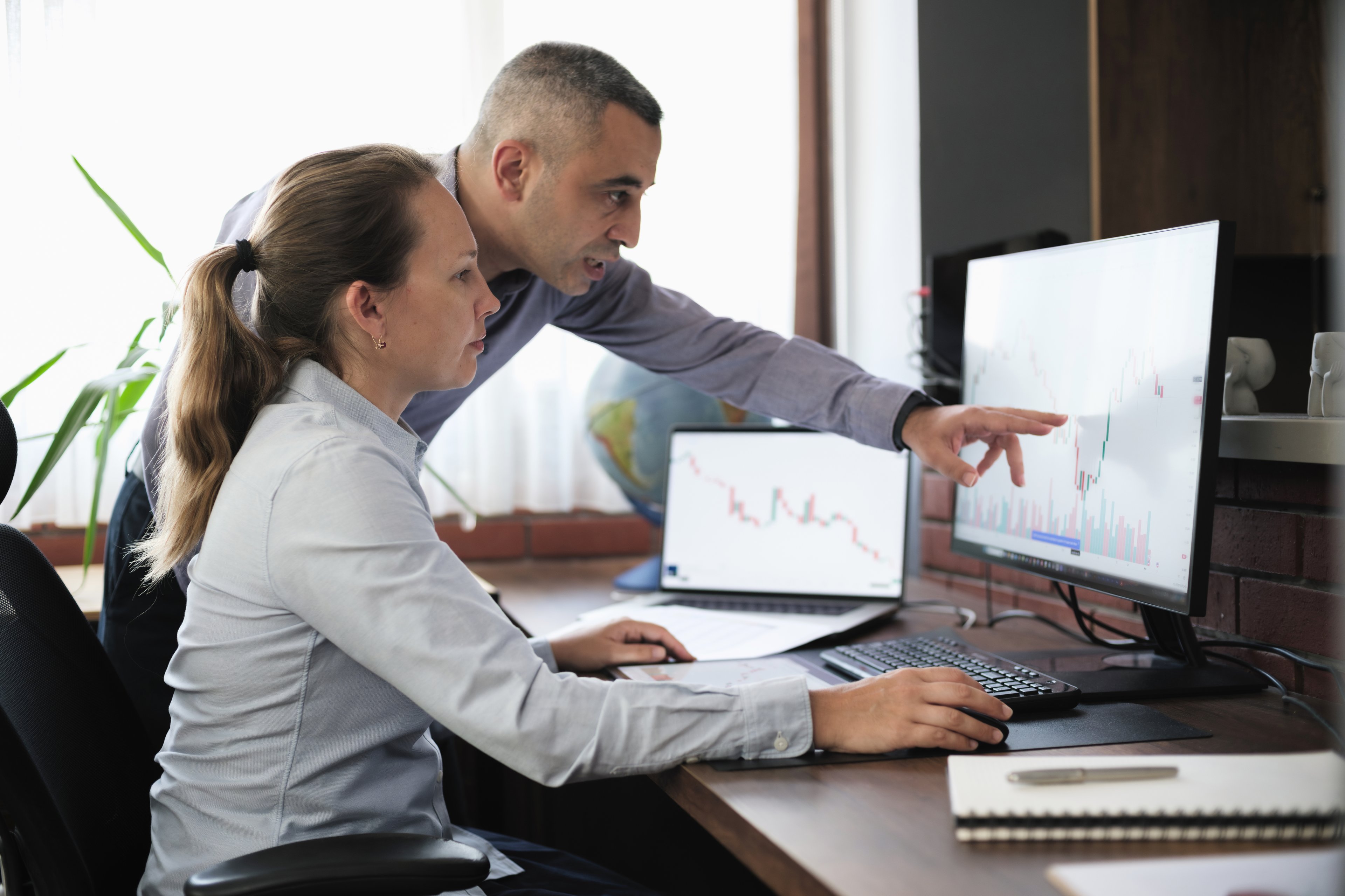 Dos personas están mirando un gráfico en una computadora.