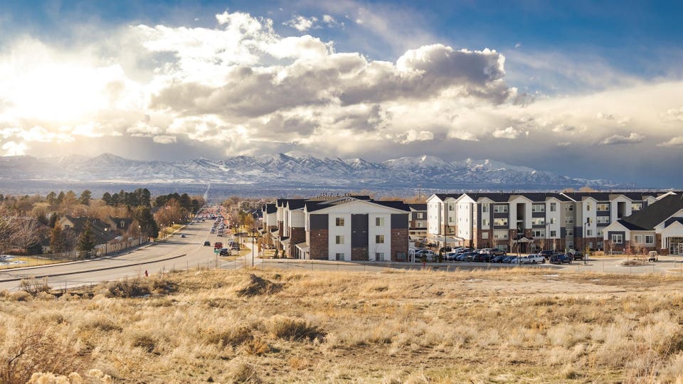 Salt Lake City, Utah Desarrollo residencial suburbano, fondo de montaña con cielo nublado junto a la carretera principal con tráfico 